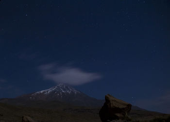 Scenic view of snowcapped mountains against sky at night