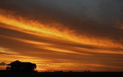 Silhouette buildings against sky during sunset