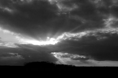 Silhouette of landscape against cloudy sky