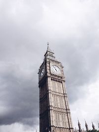 Low angle view of clock tower against cloudy sky