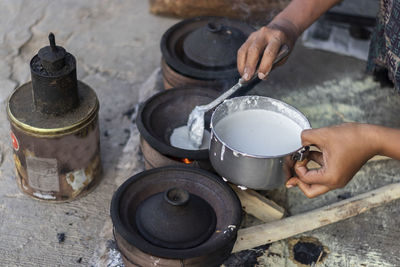 Midsection of person preparing food on barbecue grill