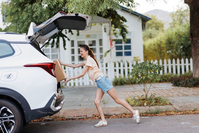 Full length of young woman walking on road