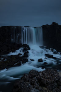 Scenic view of waterfall against sky