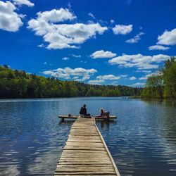 Pier on lake against cloudy sky