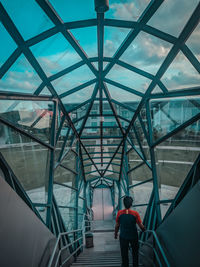 Rear view of man walking on bridge