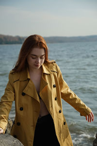 Beautiful woman standing against sea