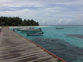 Boats moored on sea against sky