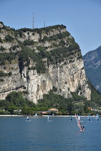 Scenic view of rocky mountains by sea against clear sky