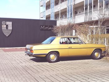 Car on street against buildings in city