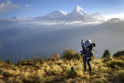 Woman standing on field against mountains