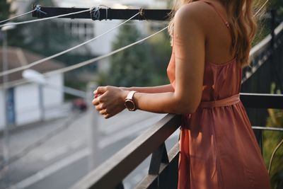 Midsection of woman standing at railing