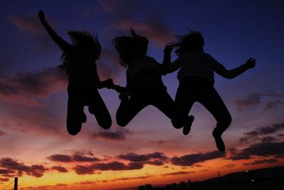 Low angle view of boy jumping at sunset