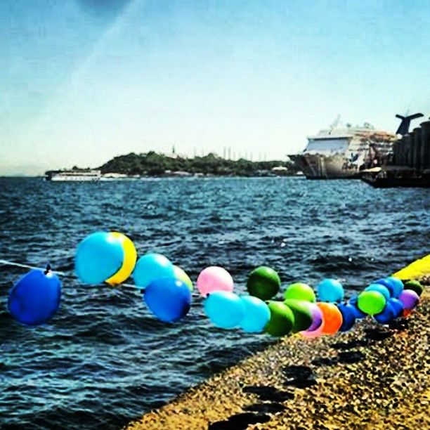 water, sea, multi colored, blue, horizon over water, transportation, buoy, rope, sky, mode of transport, tranquility, waterfront, day, protection, nautical vessel, colorful, large group of objects, tranquil scene, boat, nature