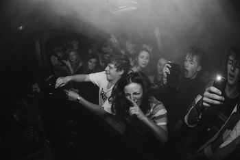 YOUNG WOMAN WITH HANDS IN ILLUMINATED NIGHTCLUB