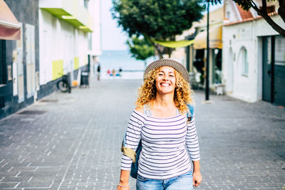 Portrait of smiling young woman standing in city