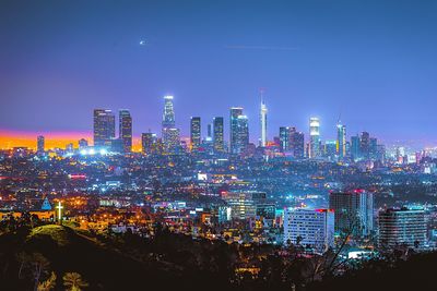 Illuminated cityscape against clear sky at night