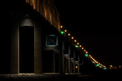 Low angle view of illuminated bridge at night