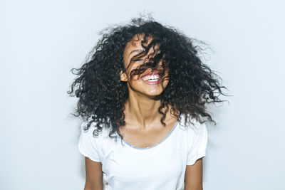 Portrait of smiling young woman against white background