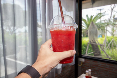 Close-up of hand holding glass of red wine