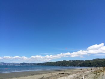 Scenic view of beach against blue sky