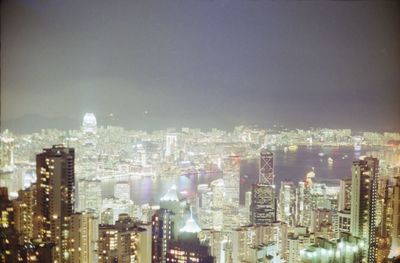 Illuminated cityscape against sky at night