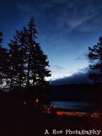 Silhouette trees by lake against sky at sunset