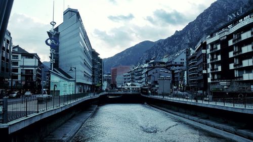 Buildings in city against cloudy sky