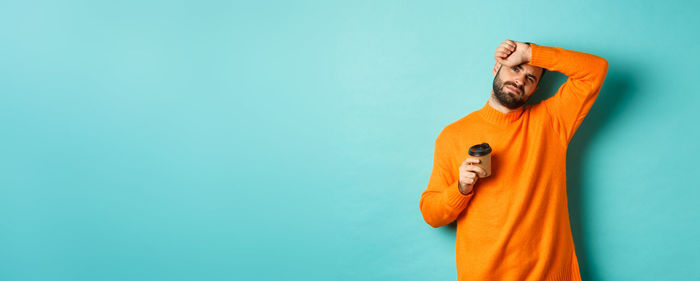 Rear view of woman standing against blue background