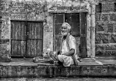 Full length of man sitting outdoors