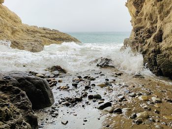 Scenic view of rocks in sea against sky