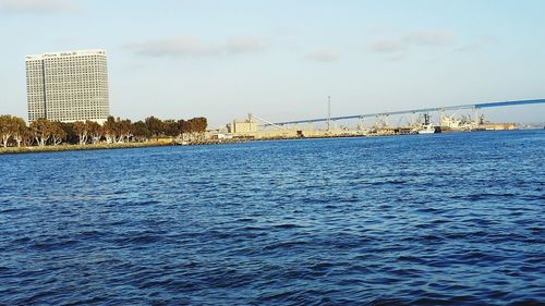 Bridge over sea against buildings in city