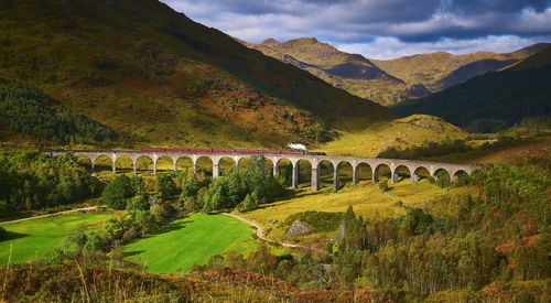 Scenic view of bridge over mountains against sky