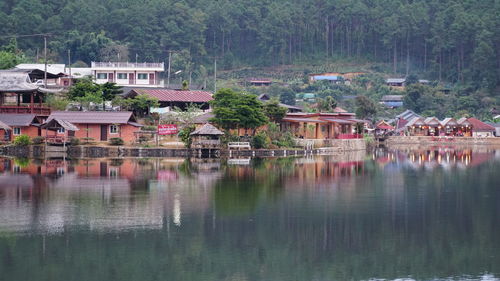Houses by lake and buildings in village