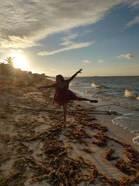 Man standing on beach against sky during sunset