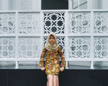 Portrait of girl in hijab leaning against railing