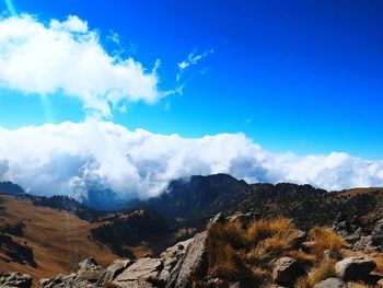 Scenic view of mountains against blue sky