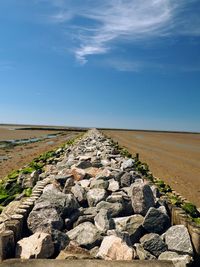 View of rocks on landscape against blue sky