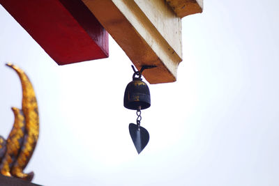 Low angle view of bell hanging against clear sky