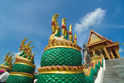 Low angle view of statue against temple building against sky