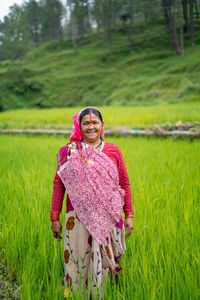 Portrait of smiling woman standing on field