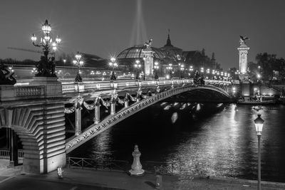 Illuminated bridge against sky at night