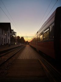 Train at railroad station against clear sky during sunset