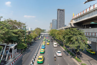 Traffic on city street by buildings against sky