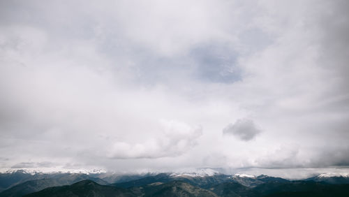 Scenic view of mountains against cloudy sky