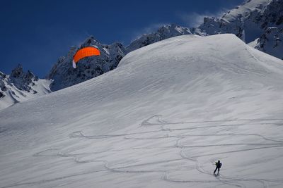 Person kiteboarding on snow covered mountain