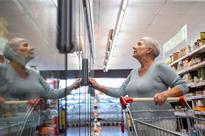 Caucasian elderly woman with white hair shopping in supermarket