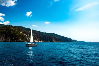 Sailboat sailing on sea against sky