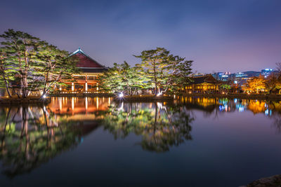 Reflection of buildings in lake against sky at night