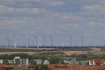 Windmills on landscape against sky