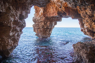 Scenic view of sea seen through cave